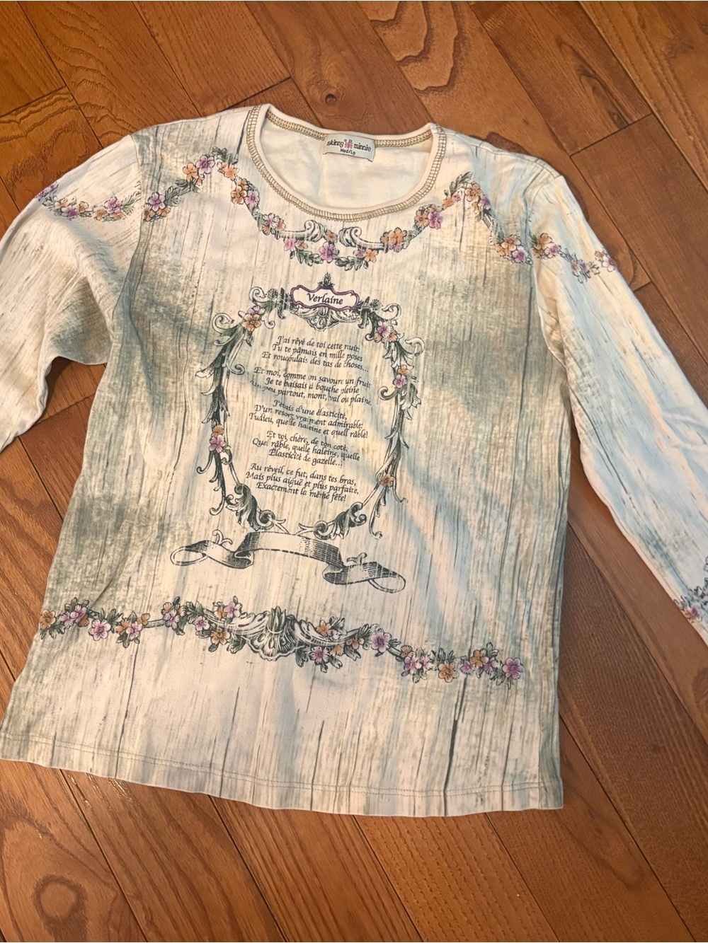 Skinny Minnie Cream Top with Pale Pink, Green and Yellow Floral Garland Accents.